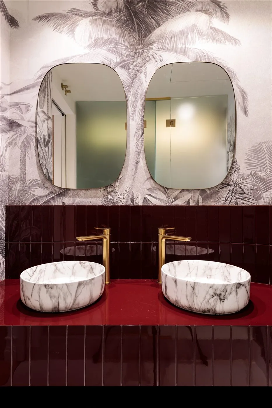 Reforma de baño con lavabos de mármol y papel pintado tropical en Madrid