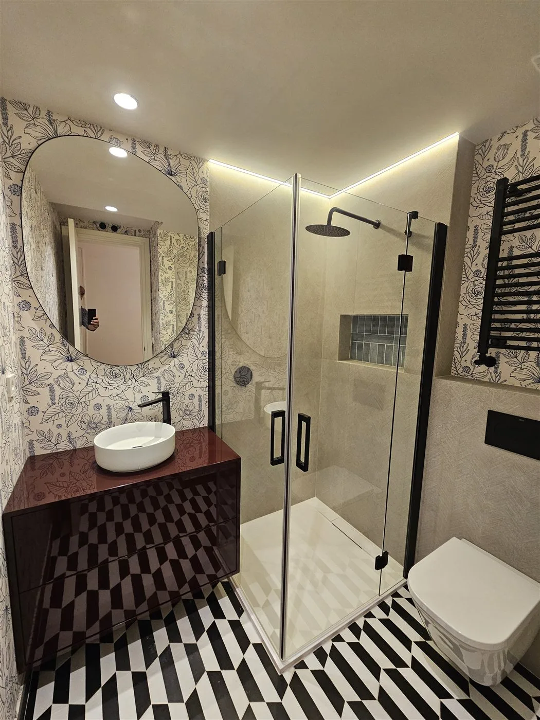 Reforma de baño singular con papel pintado floral y azulejo geométrico en Madrid