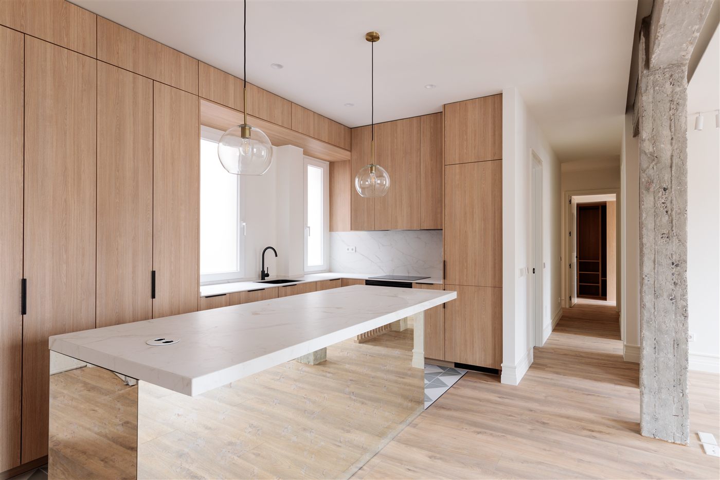 Cocina de madera natural con isla blanca reformada por Morenez Group