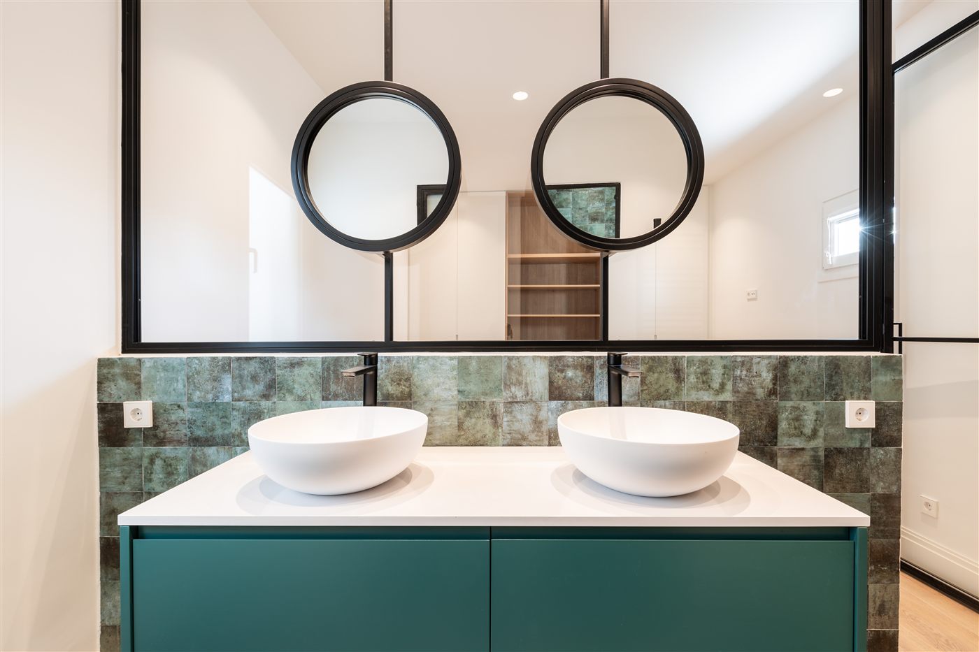 Baño doble lavabo verde con espejos redondos
