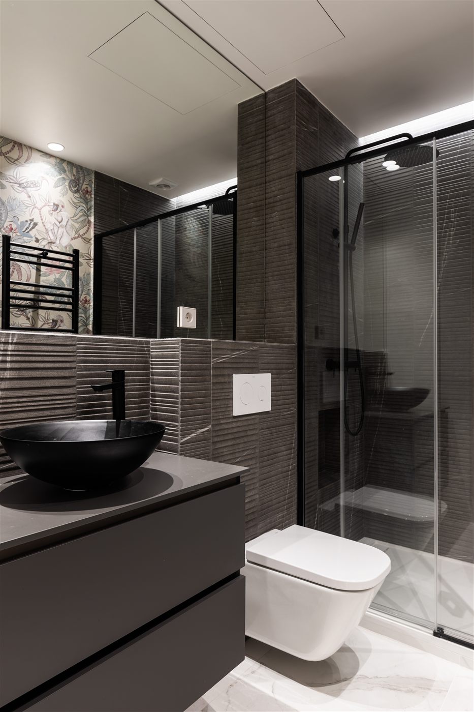 Baño gris oscuro con papel pintado floral