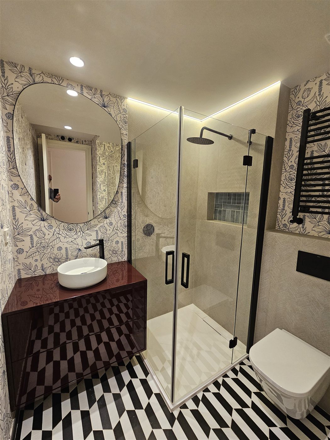 Baño singular con papel floral y azulejo geométrico