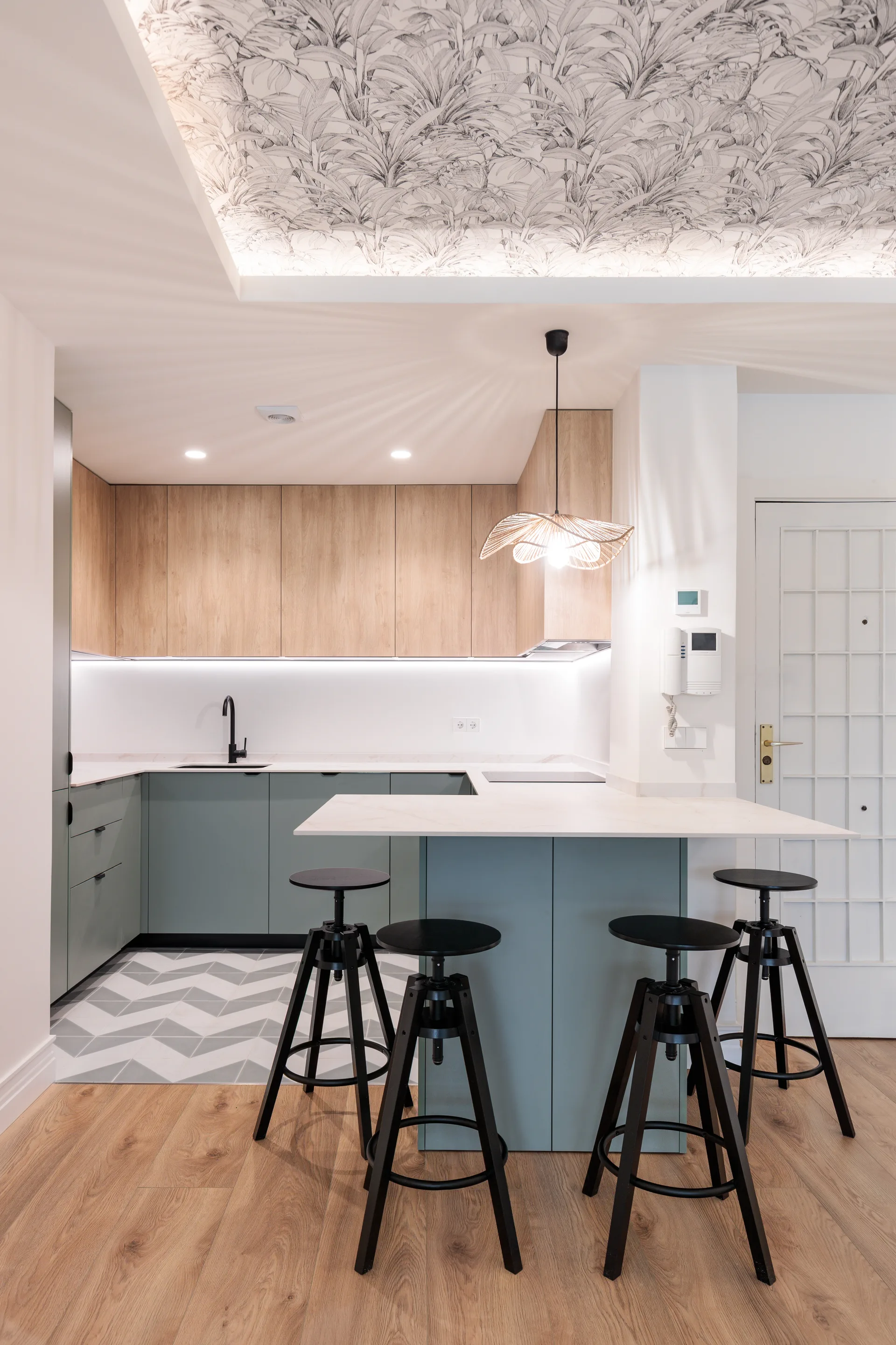 Reforma de cocina azul grisácea con isla y papel pintado en techo en Madrid